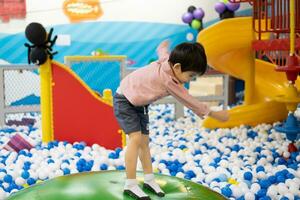 Little boy practices standing on a big inflatable ball. photo