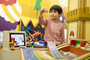 Little Asian boy playing with toy car in the children's play park photo