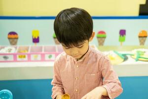 Little Asian boy playing chef cooking food photo