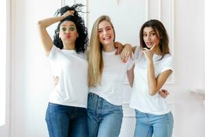 Portrait of three seductive multiethnic women standing together photo