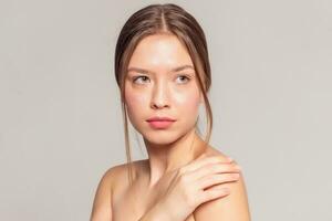 Beautiful Young Woman with Clean Fresh Skin touch own face photo