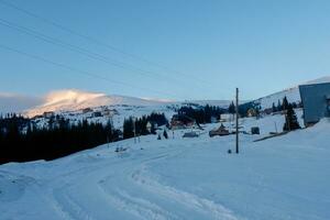 Ski piste and chair lift with snow covered trees on sunny day. photo