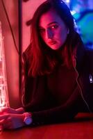 Portrait of a girl on the background of a neon sign of a shop window photo