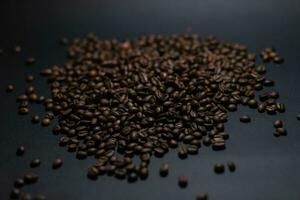 heap of coffee beans on black background photo
