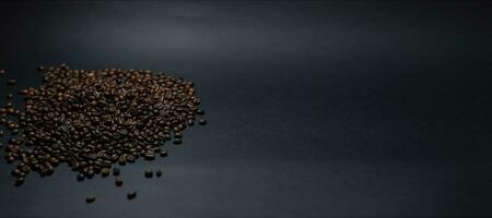 heap of coffee beans on black background photo