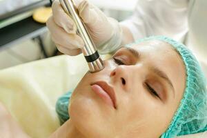 Cosmetologist makes the procedure microcurrent therapy beauty salon photo