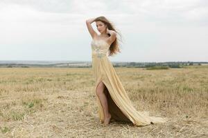 woman walking in golden dried grass field. photo