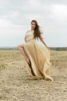 woman walking in golden dried grass field. photo