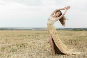 woman walking in golden dried grass field. photo