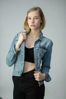 Portrait of a pretty young blond girl in a denim jacket photo