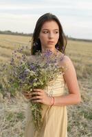 woman walking in golden dried grass field. photo