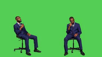 pensativo empleado pensando acerca de soluciones sentado en silla, posando terminado verde pantalla vistiendo negocio oficina traje. masculino empresario lluvia de ideas nuevo ideas y sensación seguro. foto