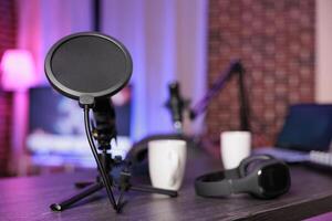 Close up shot of podcast microphone used to record internet show for online livestreaming channel. Streaming sound capturing and recording podcasting tool in empty living room with neon lights photo