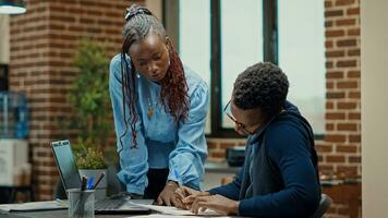 Business manager using phone call in office, explaining new company vision to increase profit. Employee and assistant reviewing documents, talking on smartphone about annual reports information. photo