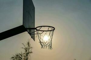 aro de baloncesto y puesta de sol foto