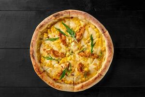 Pizza with cheese, corn, sous vide chicken filet and arugula photo