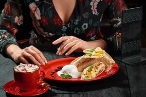 Sweet rolls of thin flatbread with tropical fruits, ice cream and cup of cocoa with marshmallow photo