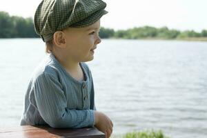 Portrait of toddler boy enjoys summer walk in countryside. photo