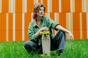 Female skateboarder with plastic skateboard outdoors. photo