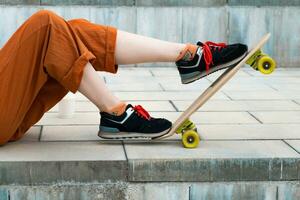 Female skateboarder legs with skateboard. photo