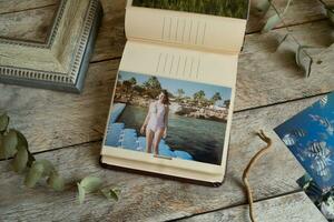 Photo album with printed photos and sample of frame on table.
