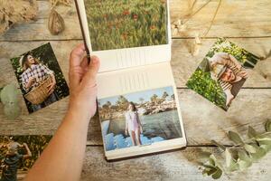 Woman looking at picture album with printed photos. Photo printing concept.