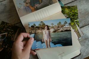 Photo printing concept. Person looks at printed photos in photo album.