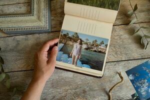 Woman browsing picture album with printed photos. photo
