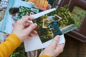 mujer mira a impreso fotos para familia foto álbum.