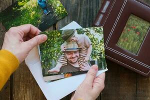 foto impresión. mujer mira a impreso fotos para familia imagen álbum.