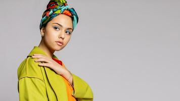 Portrait of a young woman with bright makeup and a fashionable headscarf. photo