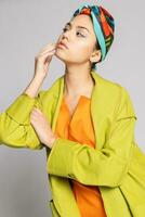 Portrait of a young woman with bright makeup and a fashionable headscarf. photo