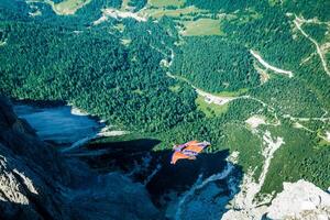 BASE jumper jumping off a big cliff in Dolomites,Italy, breathtaking photo