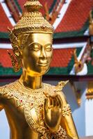 Golden Kinnari statue at Temple of Emerald Buddha Wat Phra Kaew in Grand Royal Palace. Bangkok Thailand photo