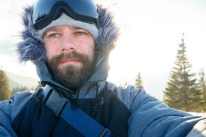 Freerider snowboarder standing on steep slope of mountain peak photo