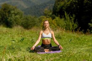 aptitud mujer sentado en un yoga actitud en un parque. foto