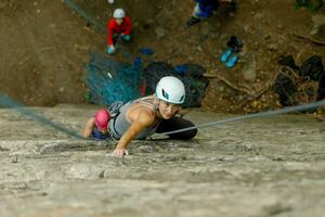 un niña sube un roca. mujer comprometido en extremo deporte. foto