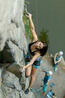 un niña sube un roca. mujer comprometido en extremo deporte. foto