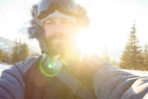 Freerider snowboarder standing on steep slope of mountain peak photo