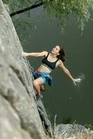 un niña sube un roca. mujer comprometido en extremo deporte. foto