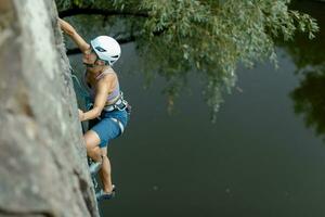 un niña sube un roca. mujer comprometido en extremo deporte. foto