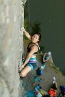 un niña sube un roca. mujer comprometido en extremo deporte. foto