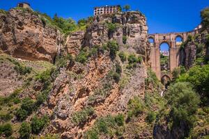 view of buildings over cliff in ronda, spain photo