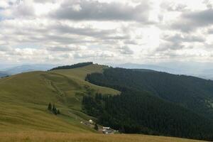 Summer landscape in mountains and the dark blue sky with clouds photo