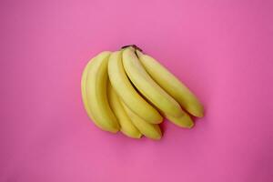 Single banana on a pink background with strong shadow photo