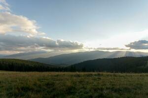 Summer landscape in mountains and the dark blue sky with clouds photo