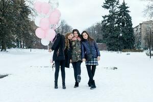 Young beautiful cheerful female friend in colorful jackets having fun photo