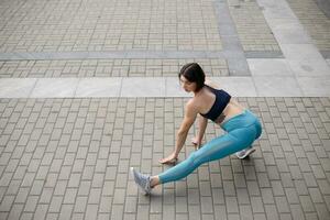 Female runner stretching after a running session in city. photo