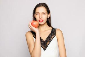 Healthy eating. Woman biting red apple with perfect teeth photo
