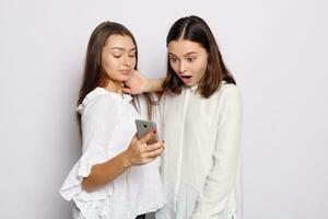 Happy smiling young woman showing photos on mobile phone